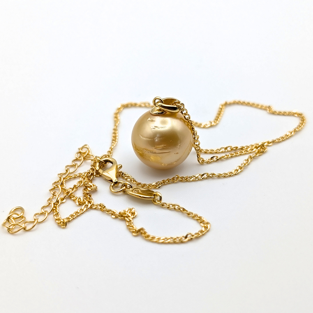 Gold necklace with a large gold south sea pearl pendant on a white background