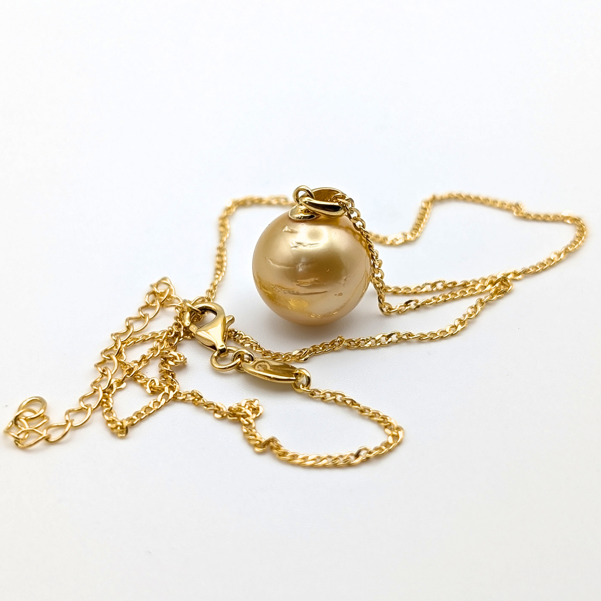 Gold necklace with a large gold south sea pearl pendant on a white background