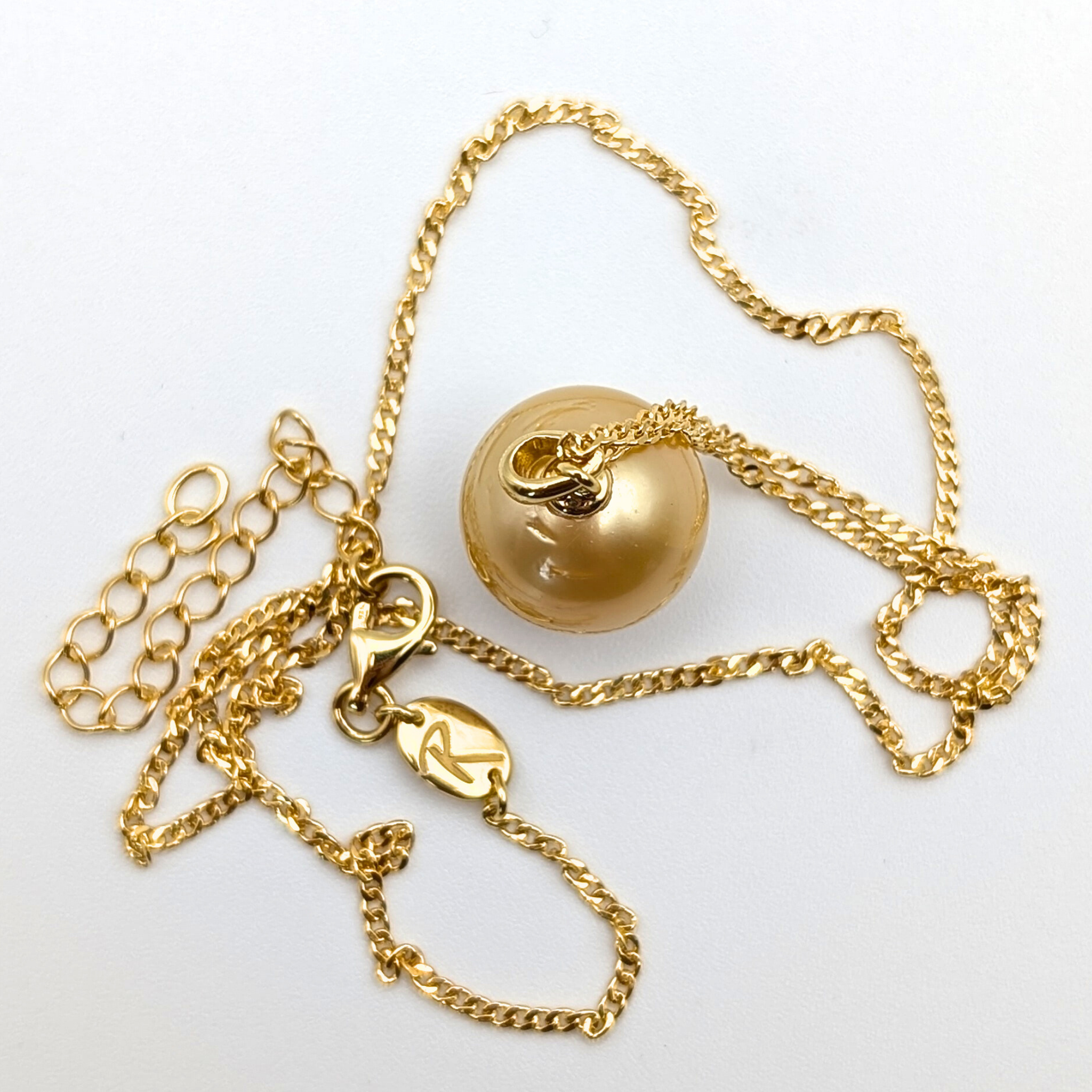 Gold necklace with a large gold south sea pearl pendant on a white background