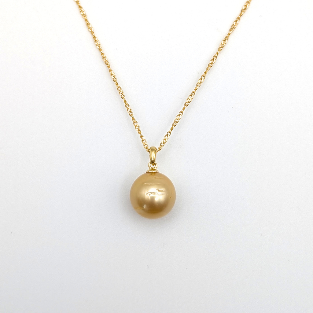 Gold necklace with a large gold south sea pearl pendant on a white background