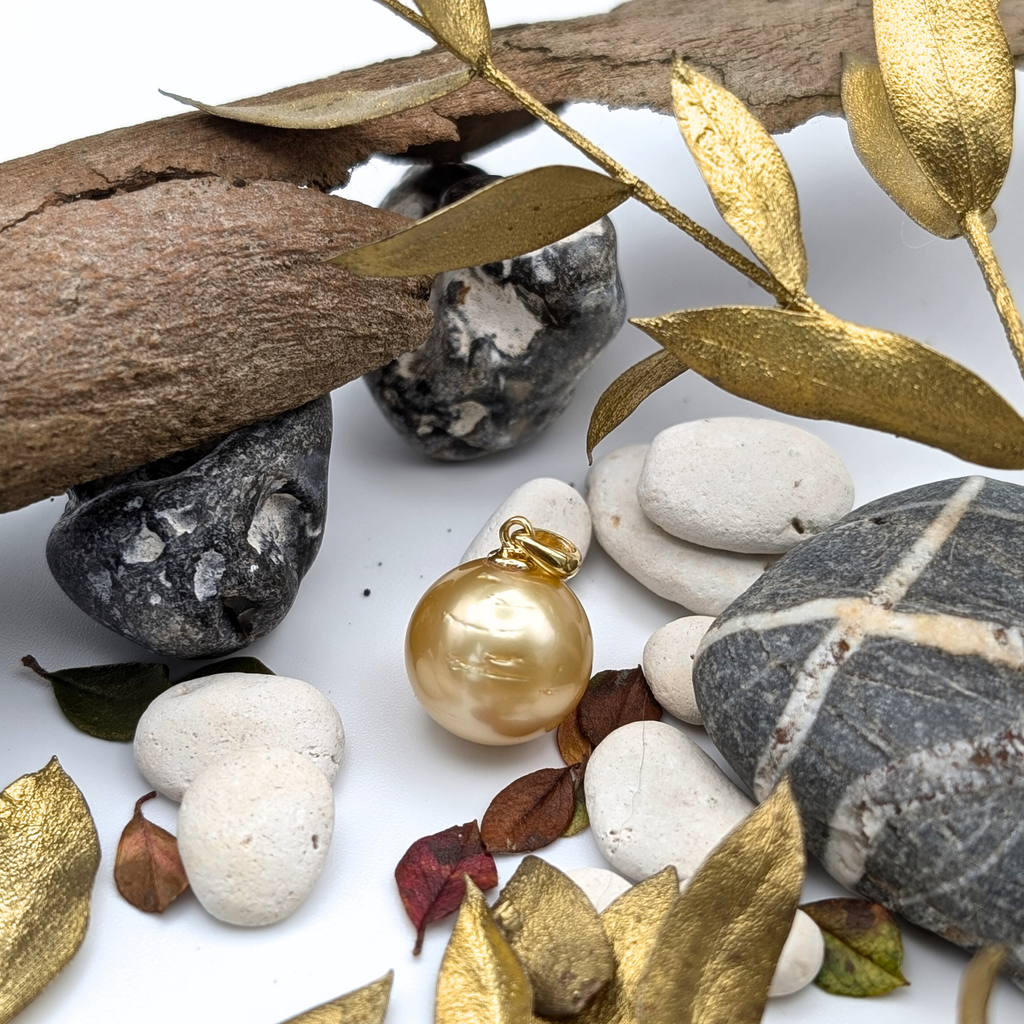 Gold necklace with a large gold south sea pearl pendant on a lifestyle background