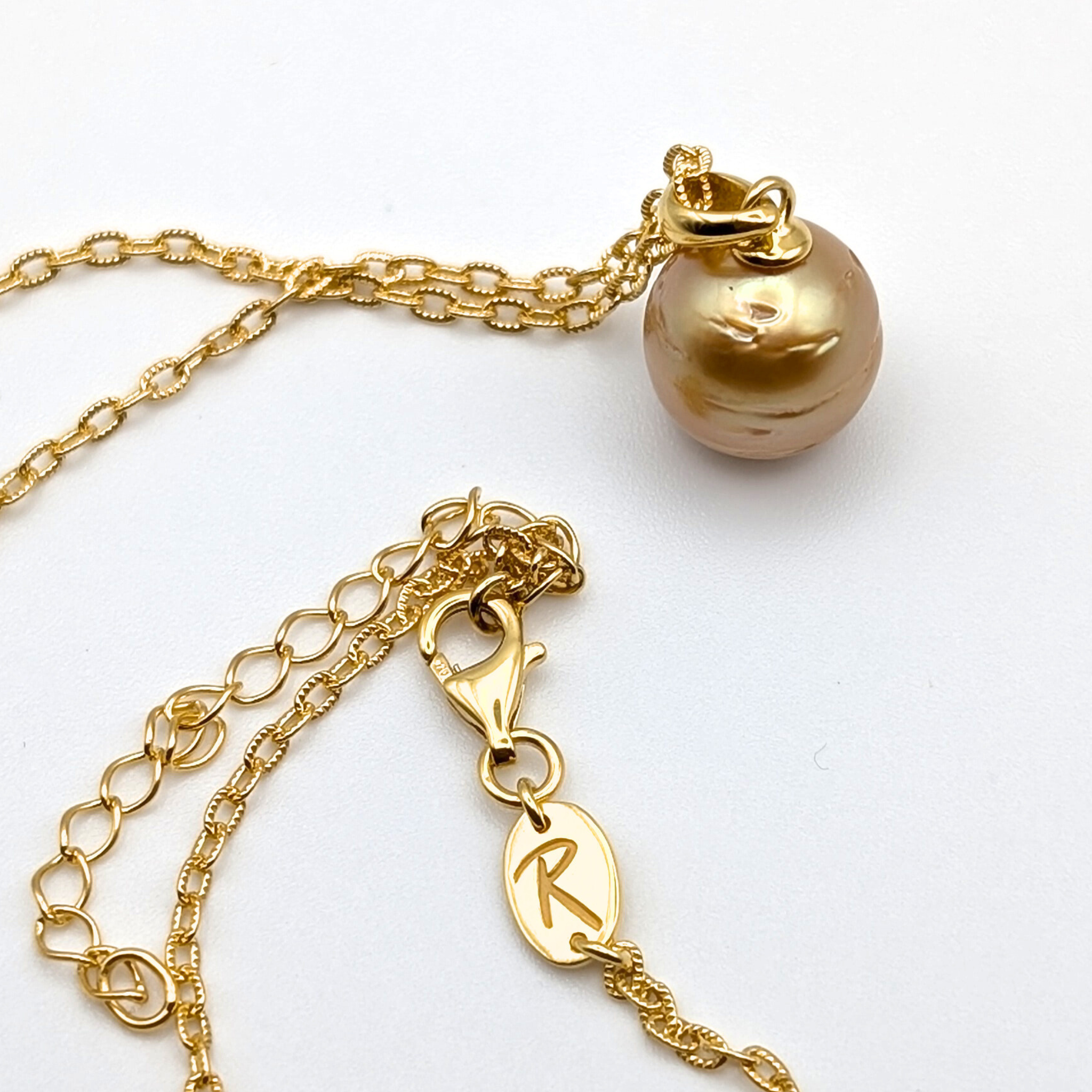 Gold striped south sea pearl pendant necklace with gold vermeil necklace on a white background
