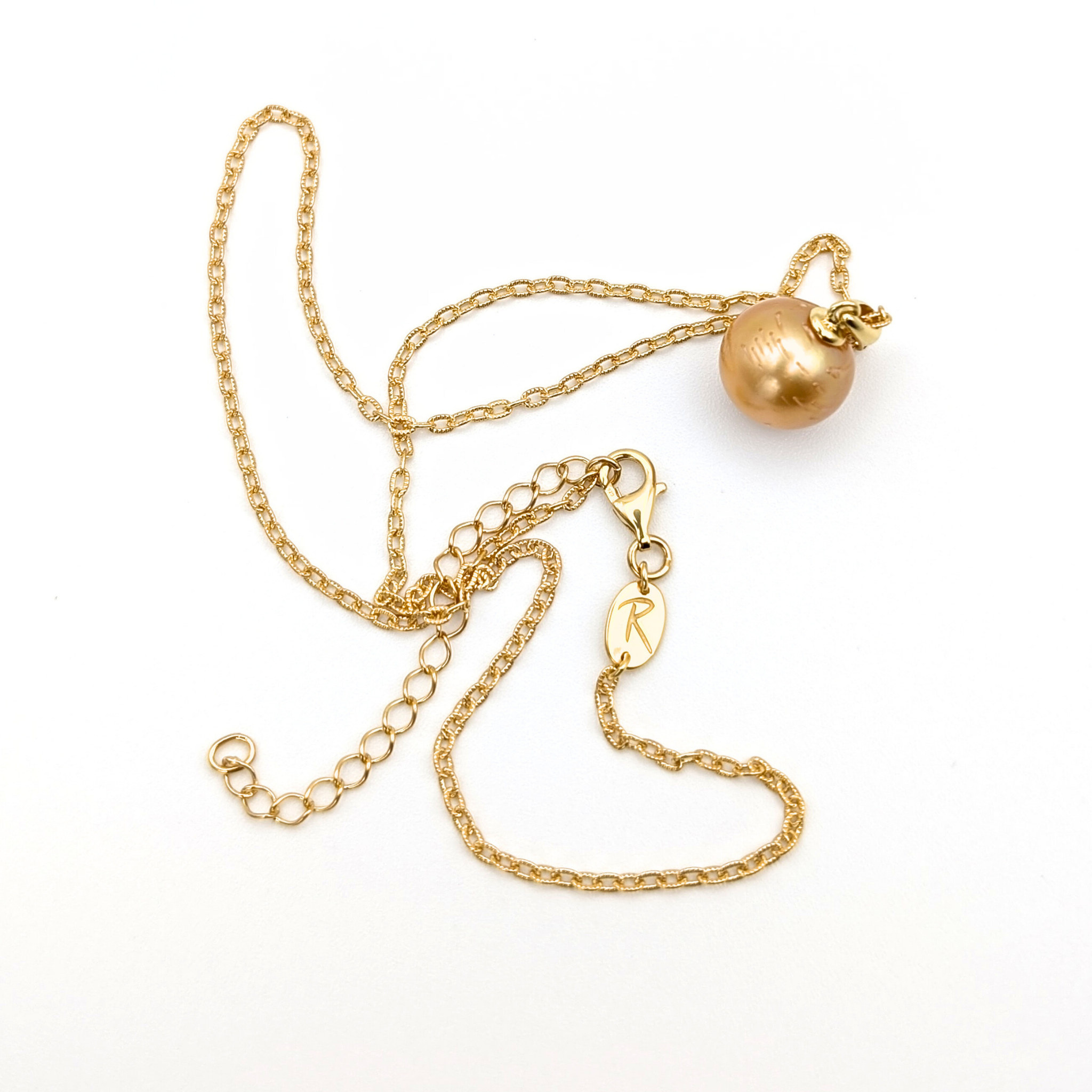 Gold necklace with a single golden south sea pearl pendant on a white background