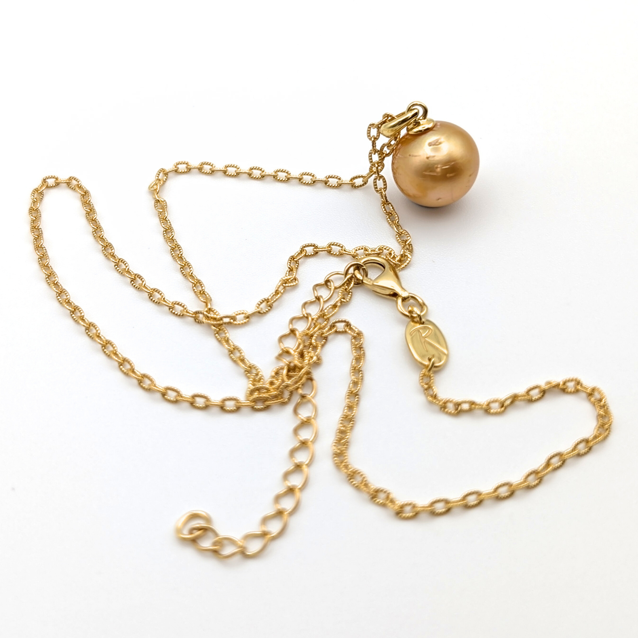 Gold necklace with a single golden south sea pearl pendant on a white background