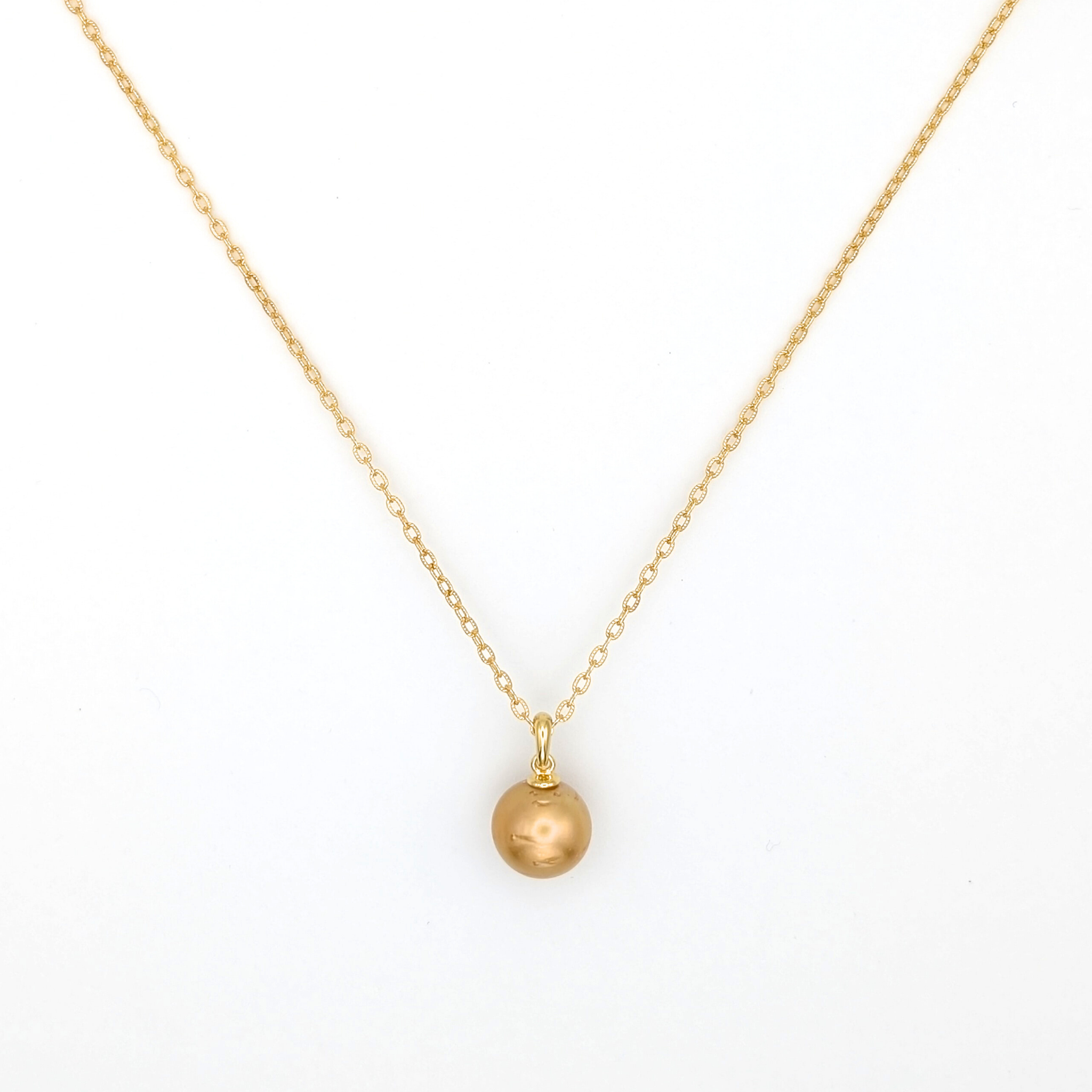 Gold necklace with a single golden south sea pearl pendant on a white background