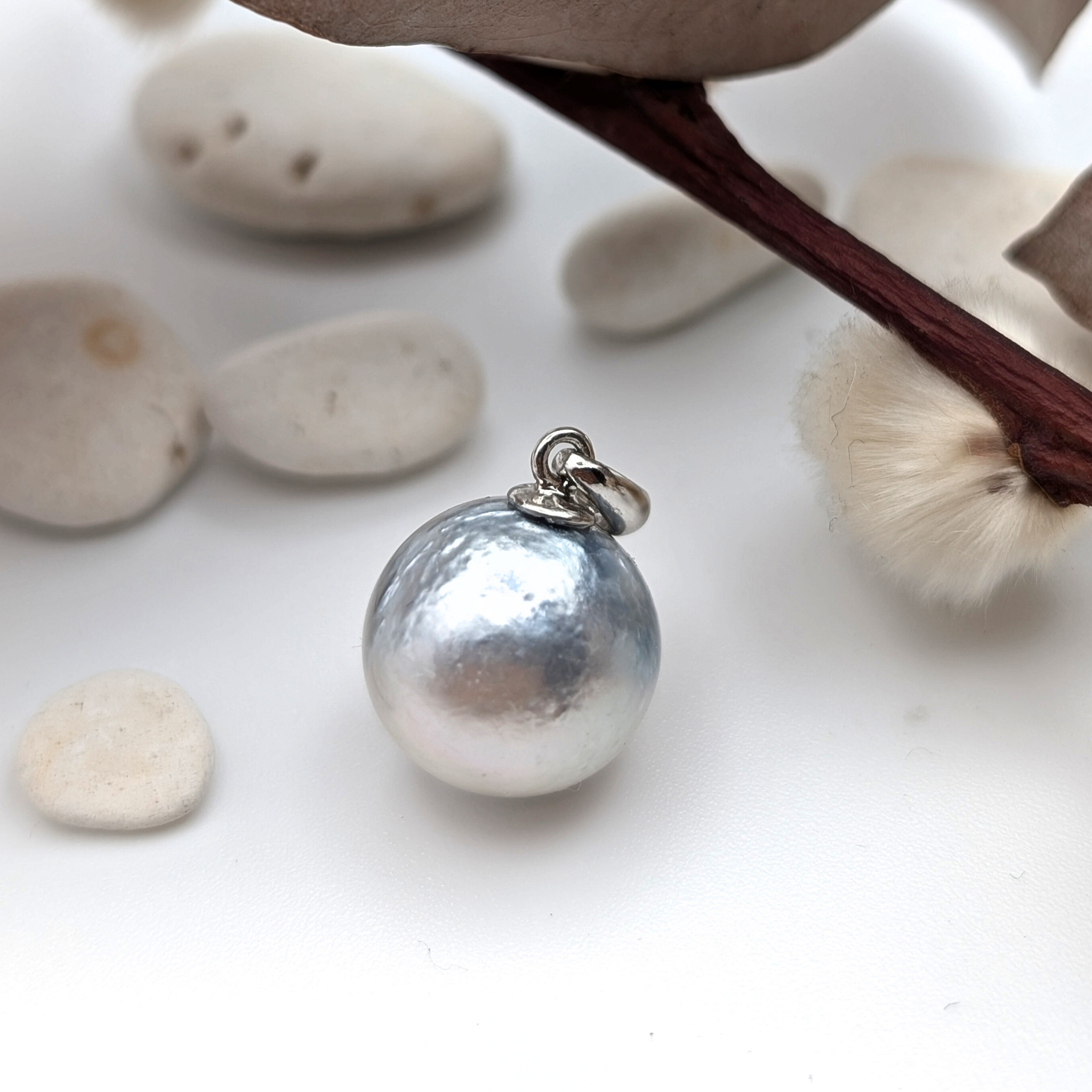 Necklace with a single silver south sea  pearl pendant on rhodium plated chain with pebble background