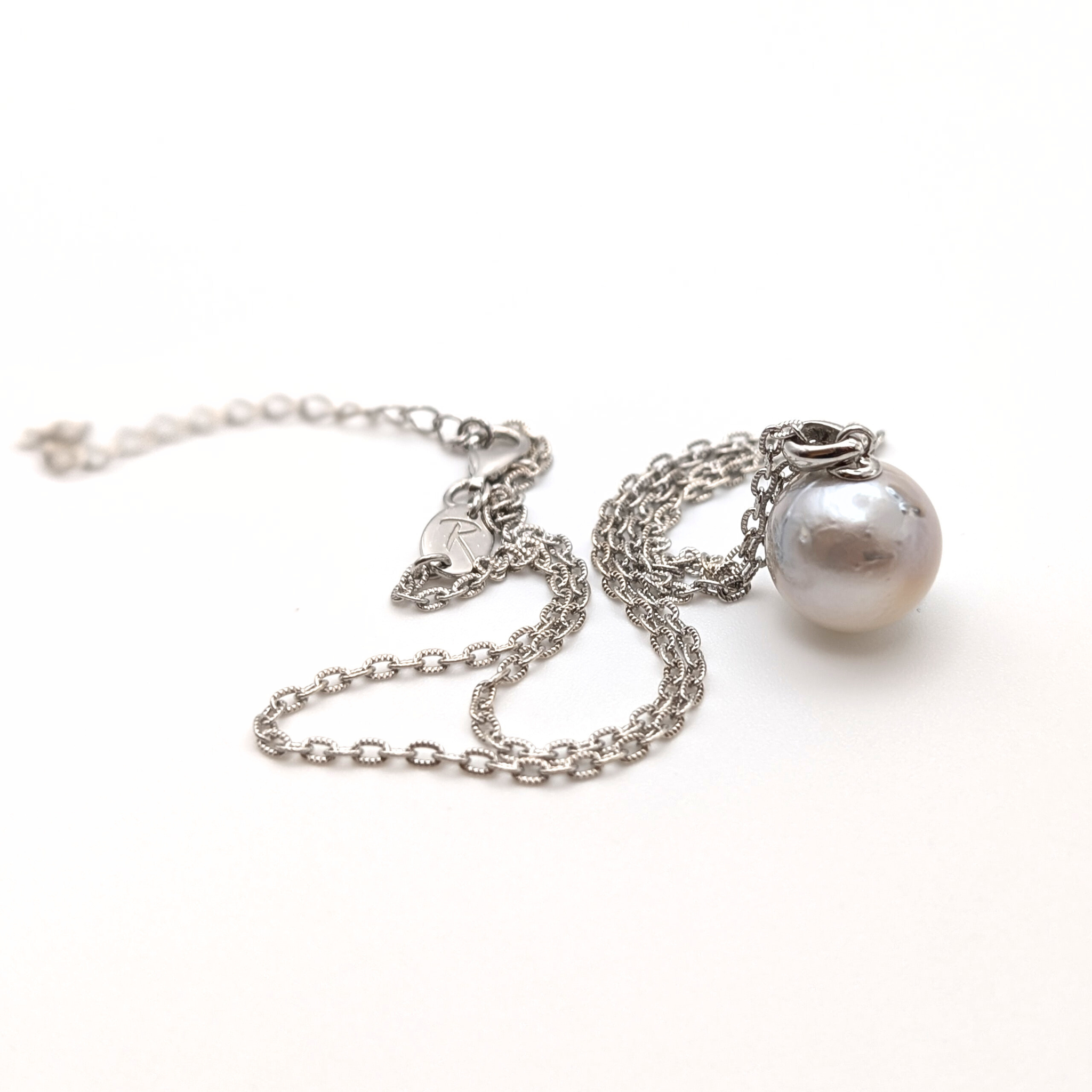 Silver south sea pearl pendant necklace with rhodium plated silver chain on a white background
