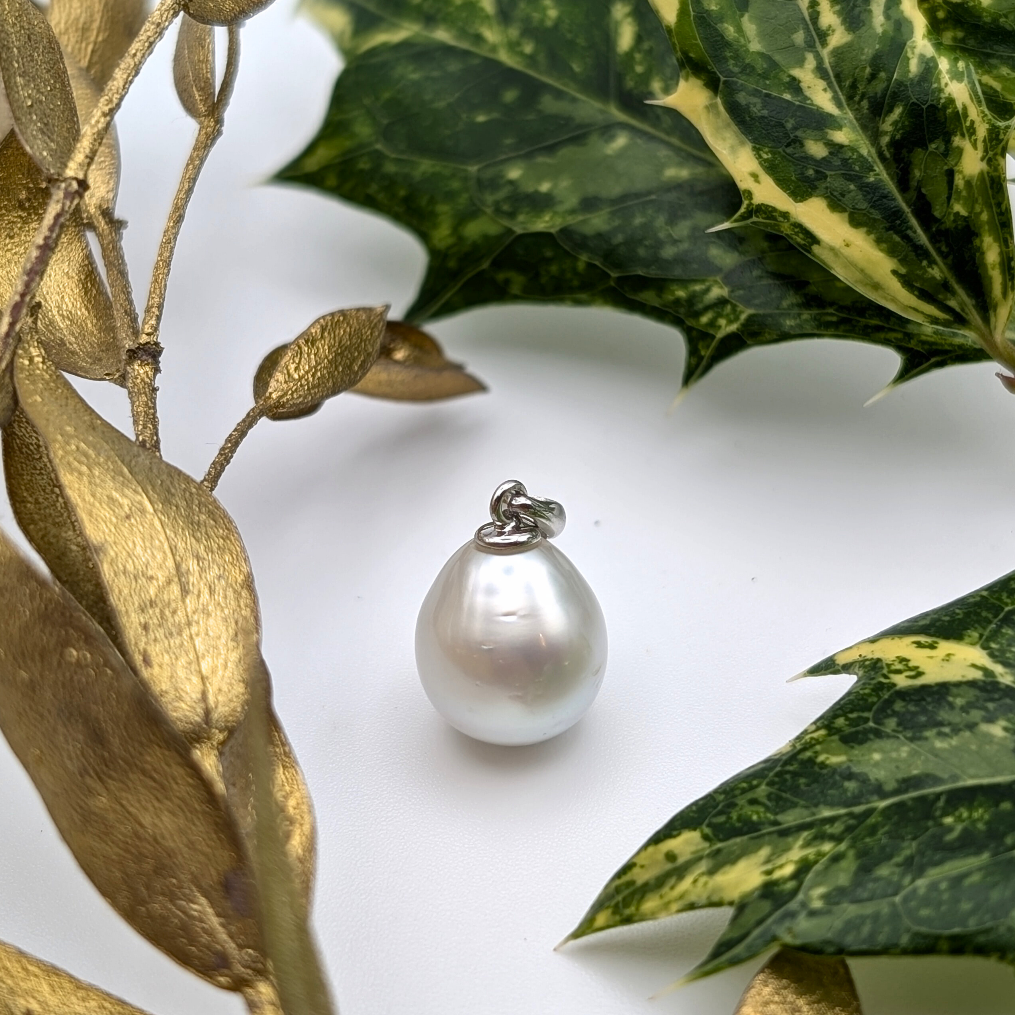 Silver teardrop shaped south sea pearl pendant on a rhodium plated sterling silver chain with lifestyle background