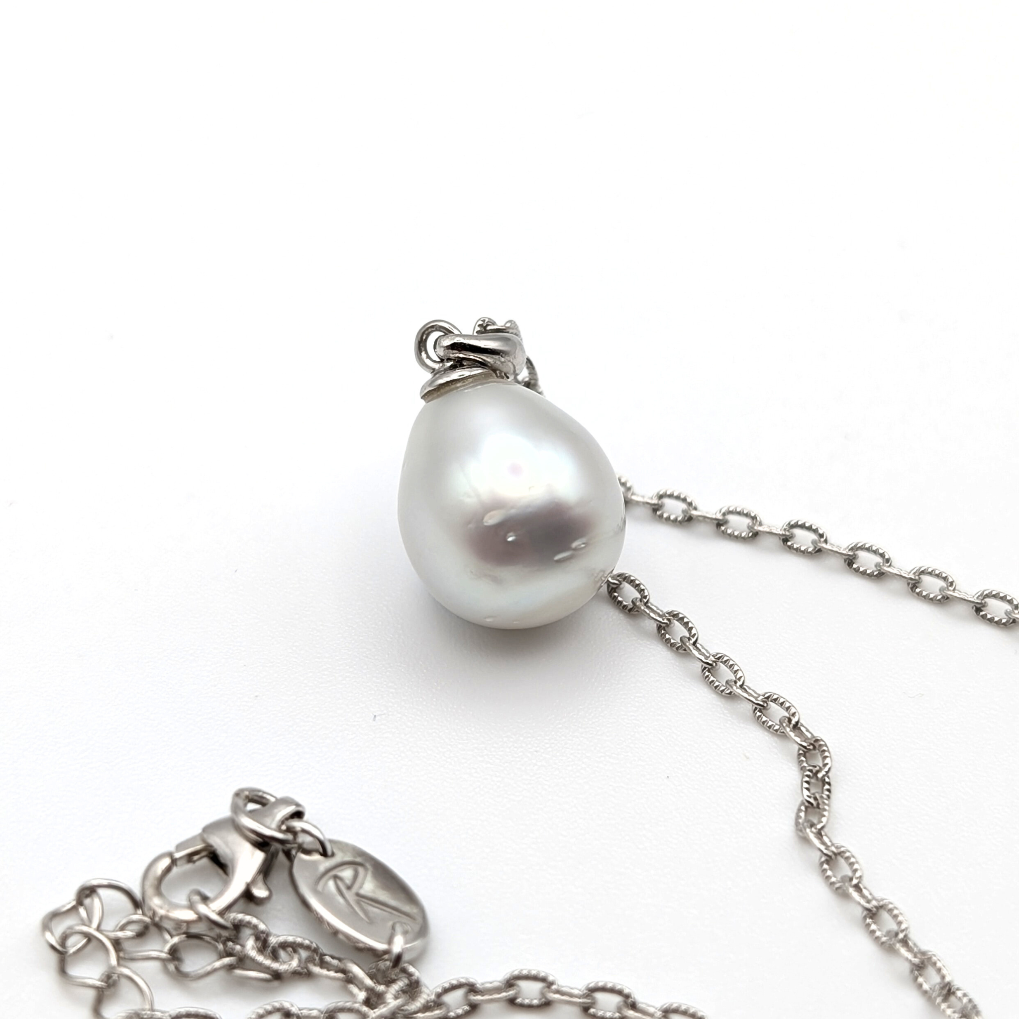 Silver teardrop shaped south sea pearl pendant on a rhodium plated sterling silver chain with a white background