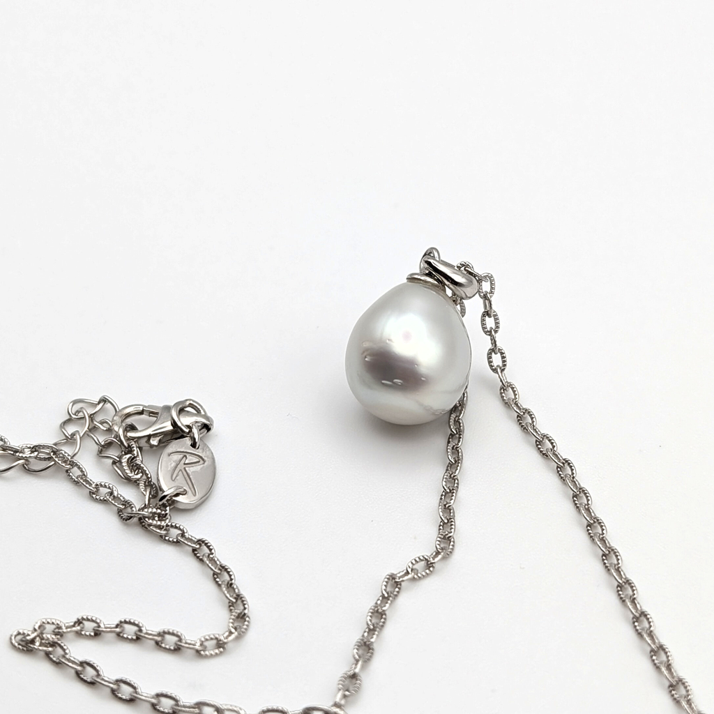 Silver teardrop shaped south sea pearl pendant on a rhodium plated sterling silver chain with a white background