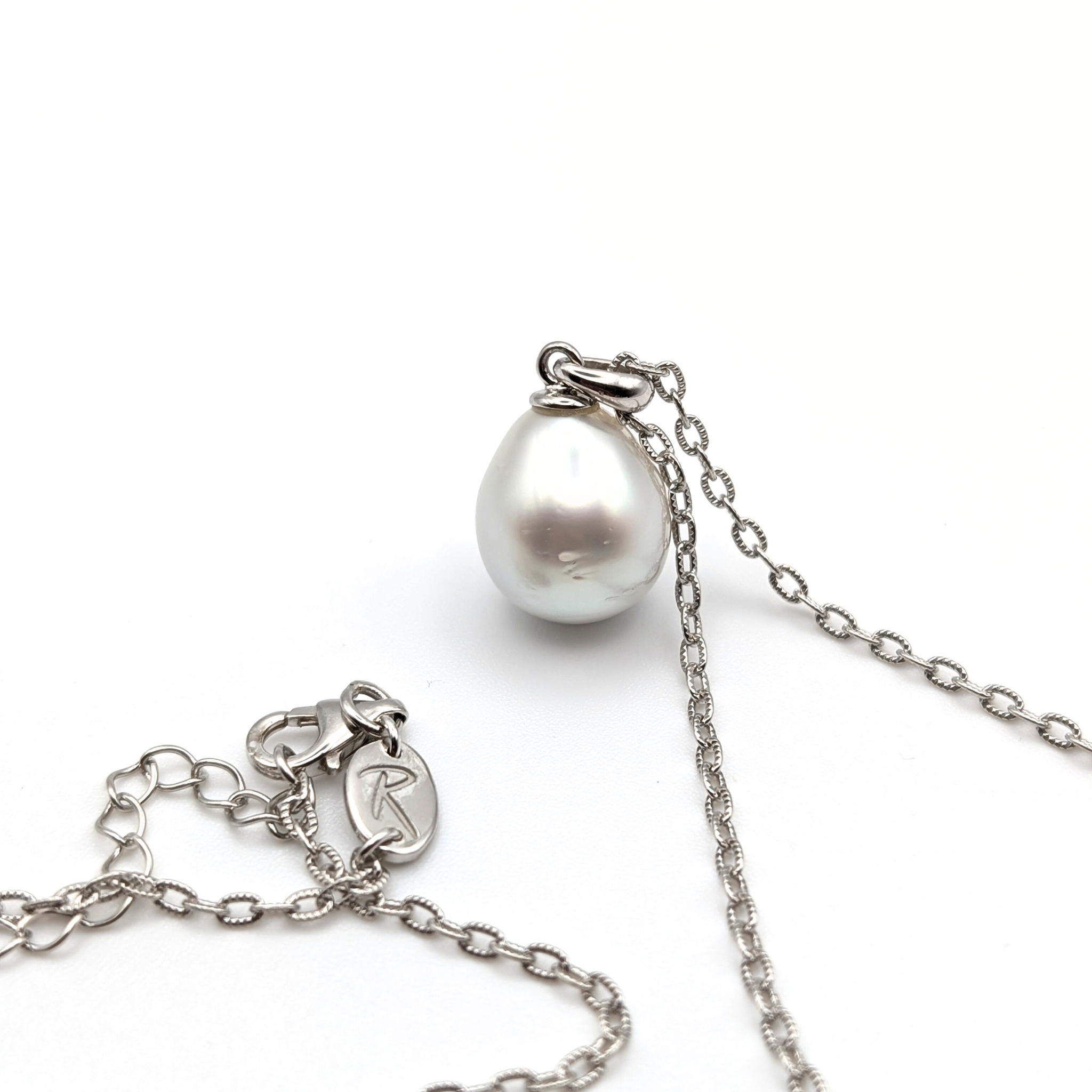 Silver teardrop shaped south sea pearl pendant on a rhodium plated sterling silver chain with a white background