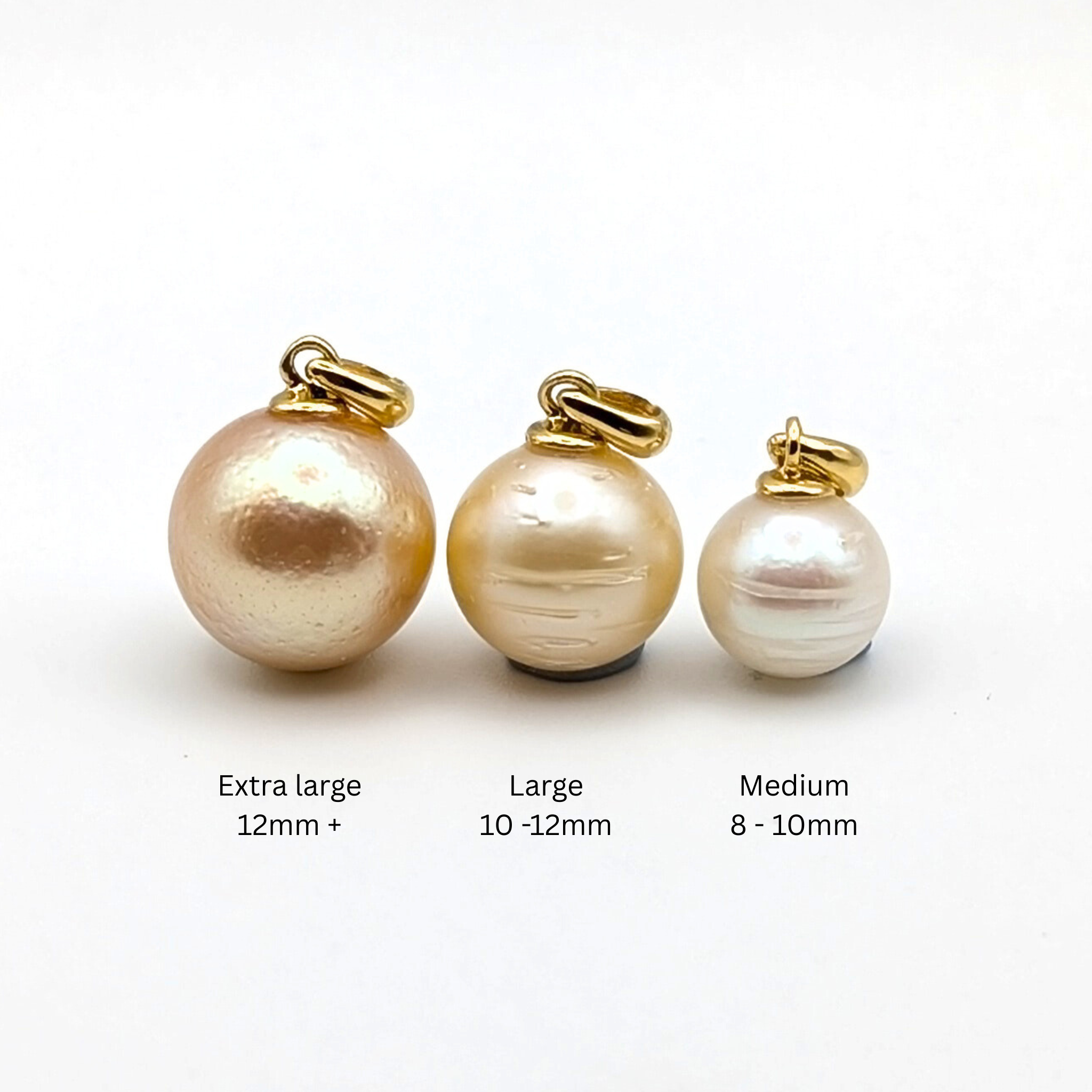 Three South Sea pearl pendants with gold bails labelled 'Extra large', 'Large', and 'Medium' on a white background.