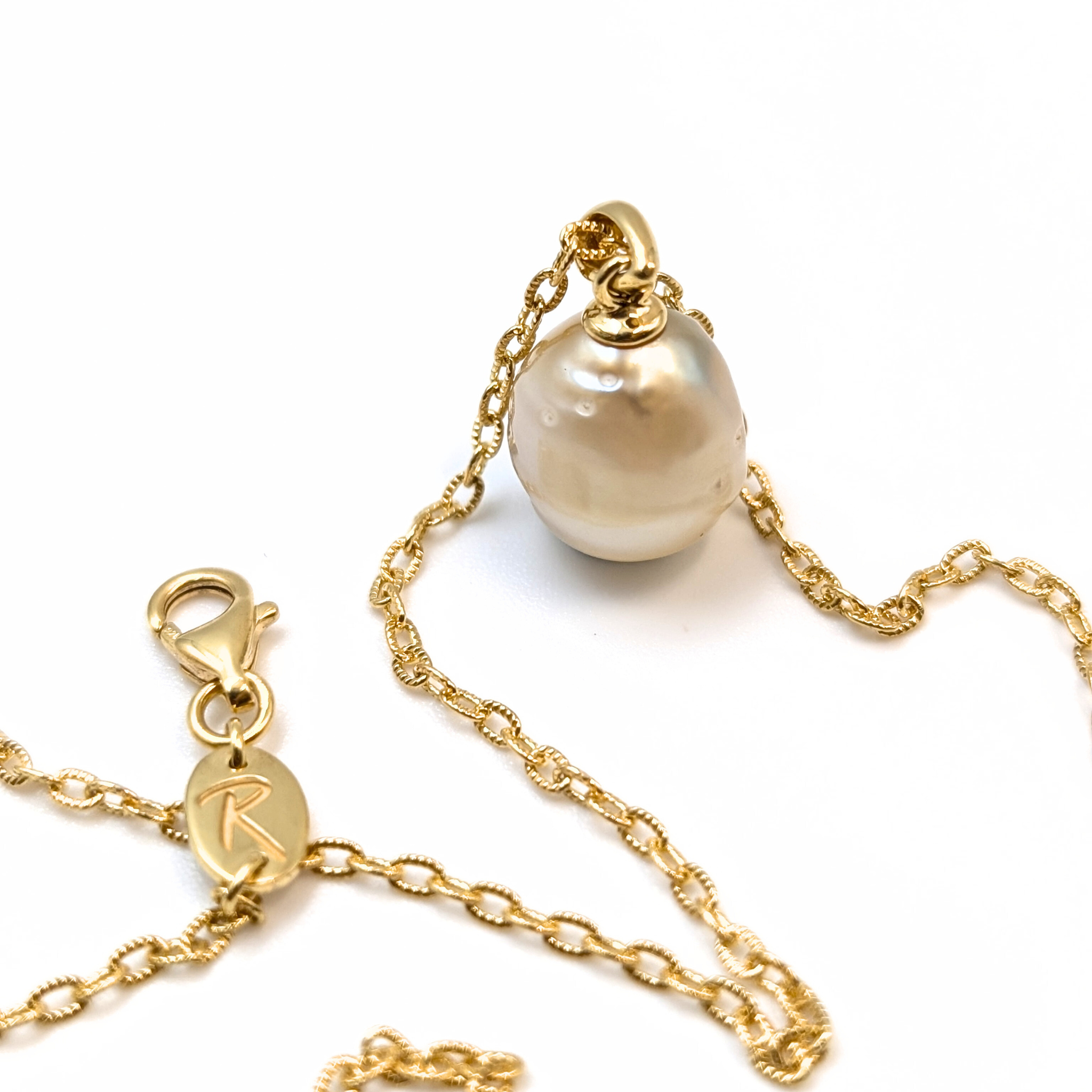 Gold vermeil pendant necklace with a gold spotted south sea pearl pendant on a white background