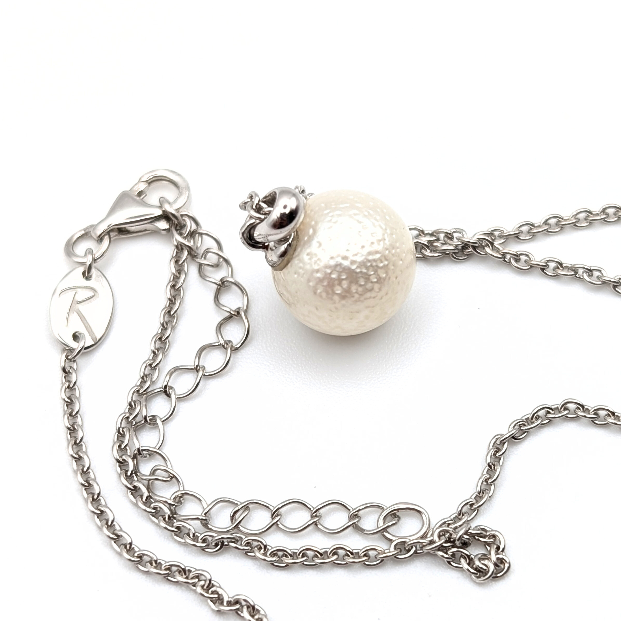 Spotted large white south sea pearl pendant necklace with rhodium plated sterling silver chain on white background
