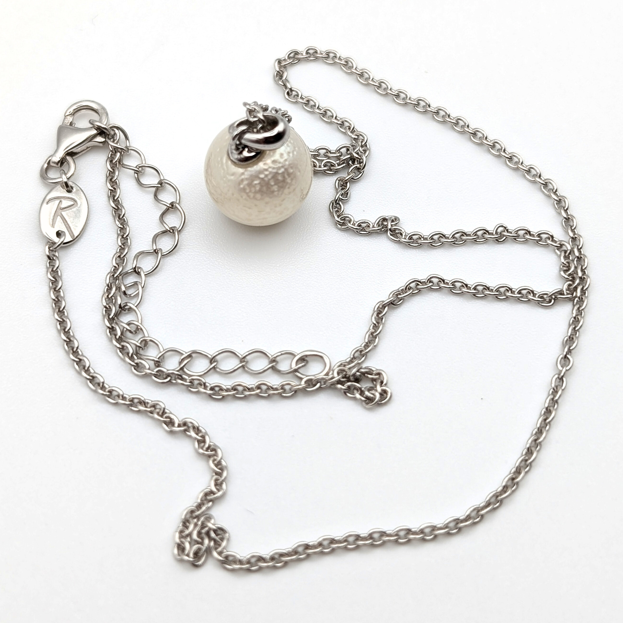 Spotted large white south sea pearl pendant necklace with rhodium plated sterling silver chain on white background