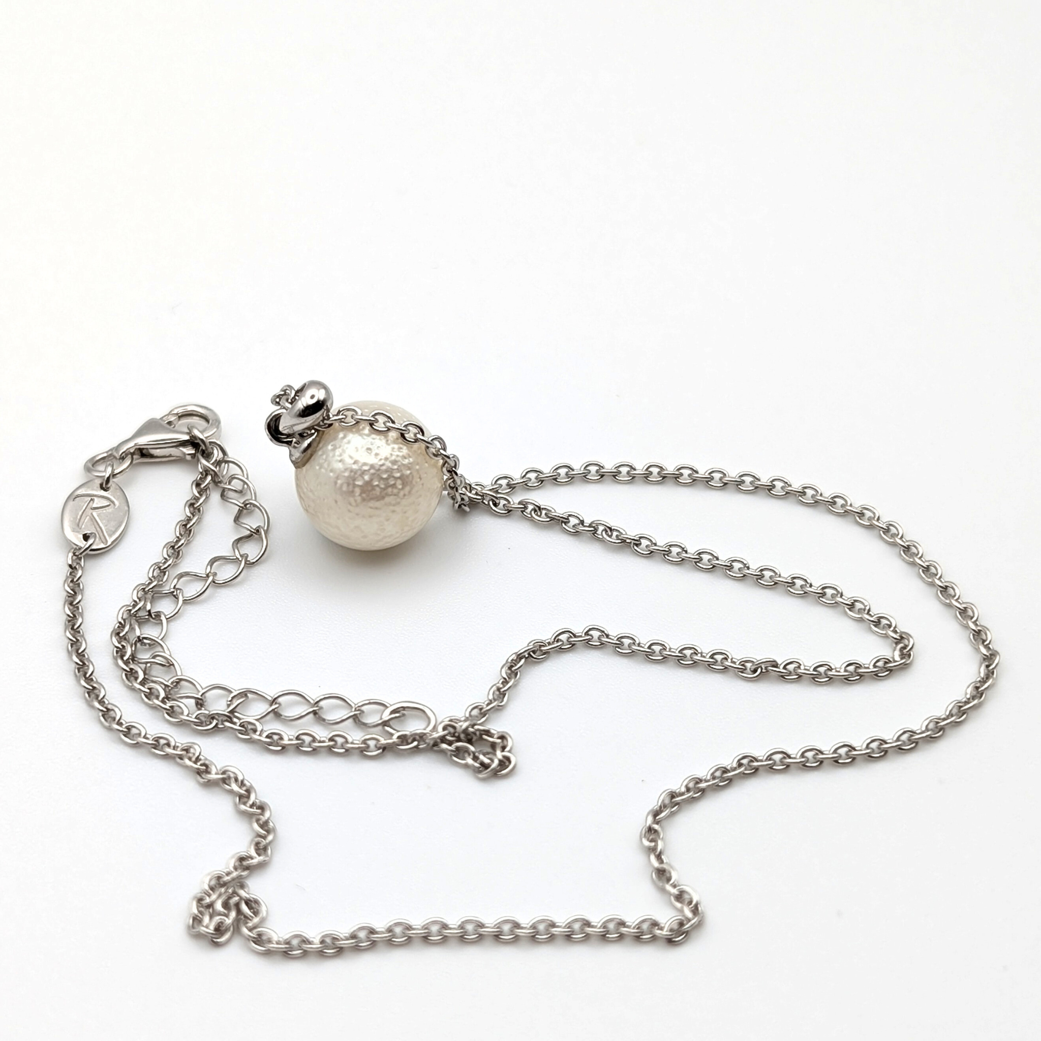 Spotted large white south sea pearl pendant necklace with rhodium plated sterling silver chain on white background