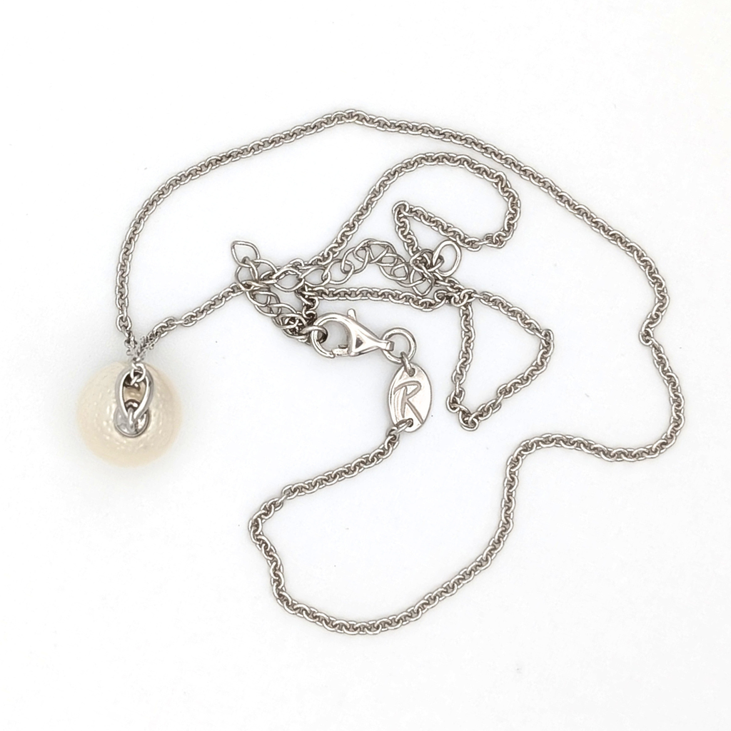 Spotted large white south sea pearl pendant necklace with rhodium plated sterling silver chain on white background