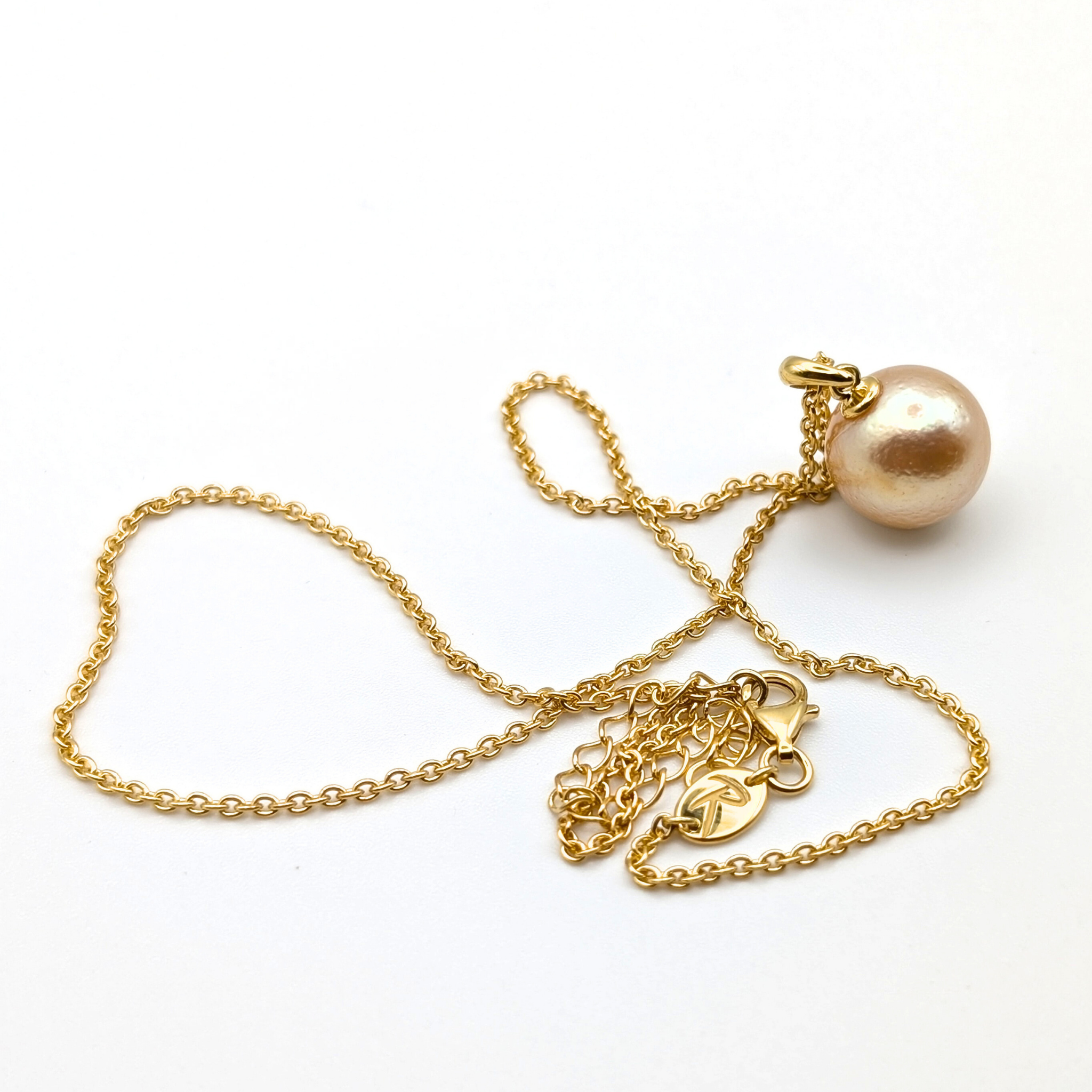 coppery gold south sea pearl pendant necklace with gold vermeil bail and chain on white background