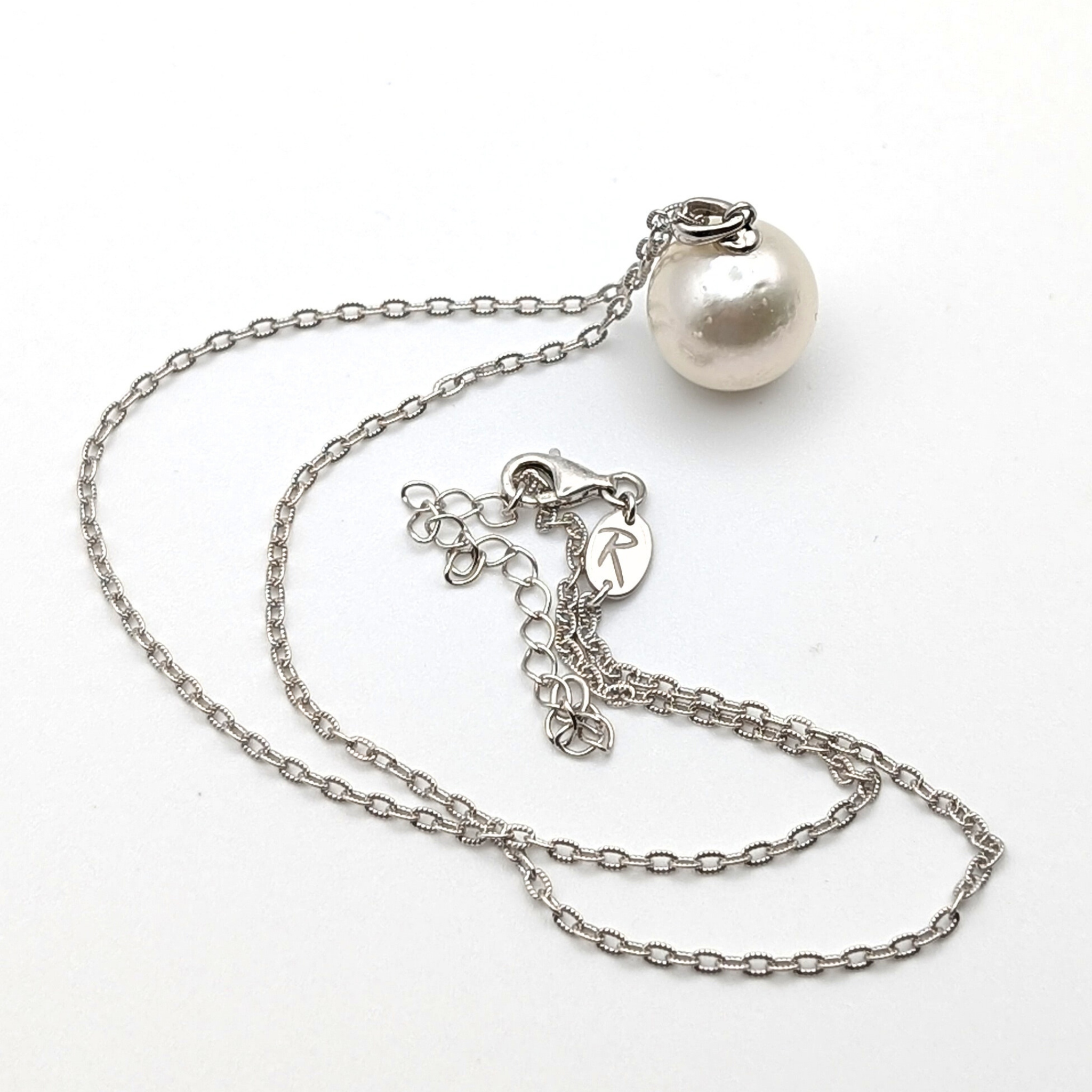 Extra large silver south sea pearl pendant necklace with rhodium plated sterling silver chain on white background