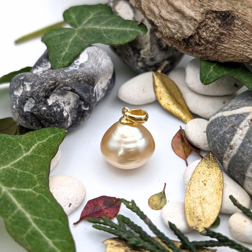 large gold south sea pearl pendant on pebbles and leaves