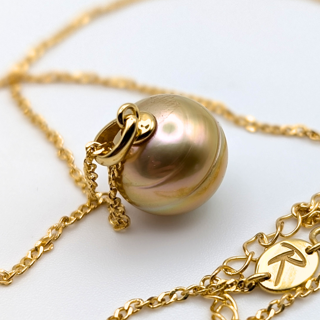 Gold necklace with a large gold south sea pearl pendant on a white background