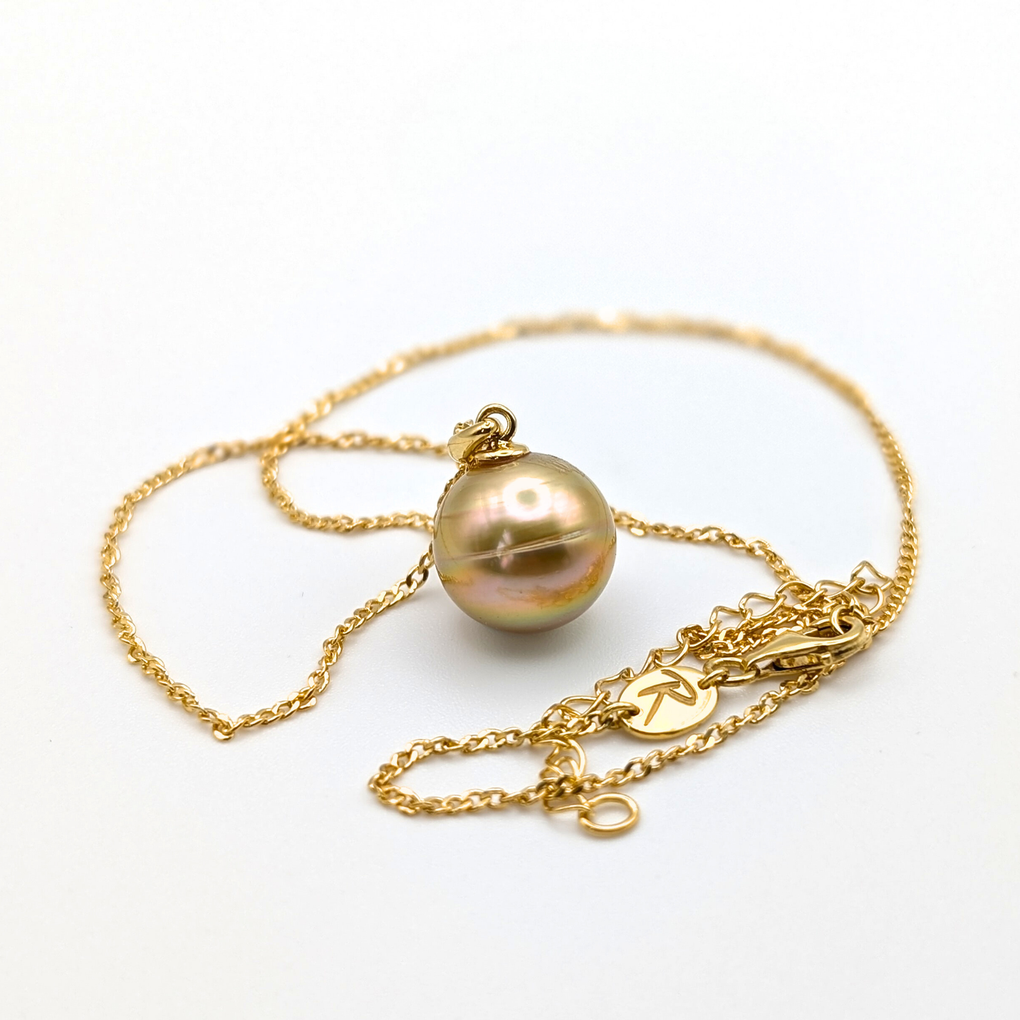 Gold necklace with a large gold south sea pearl pendant on a white background
