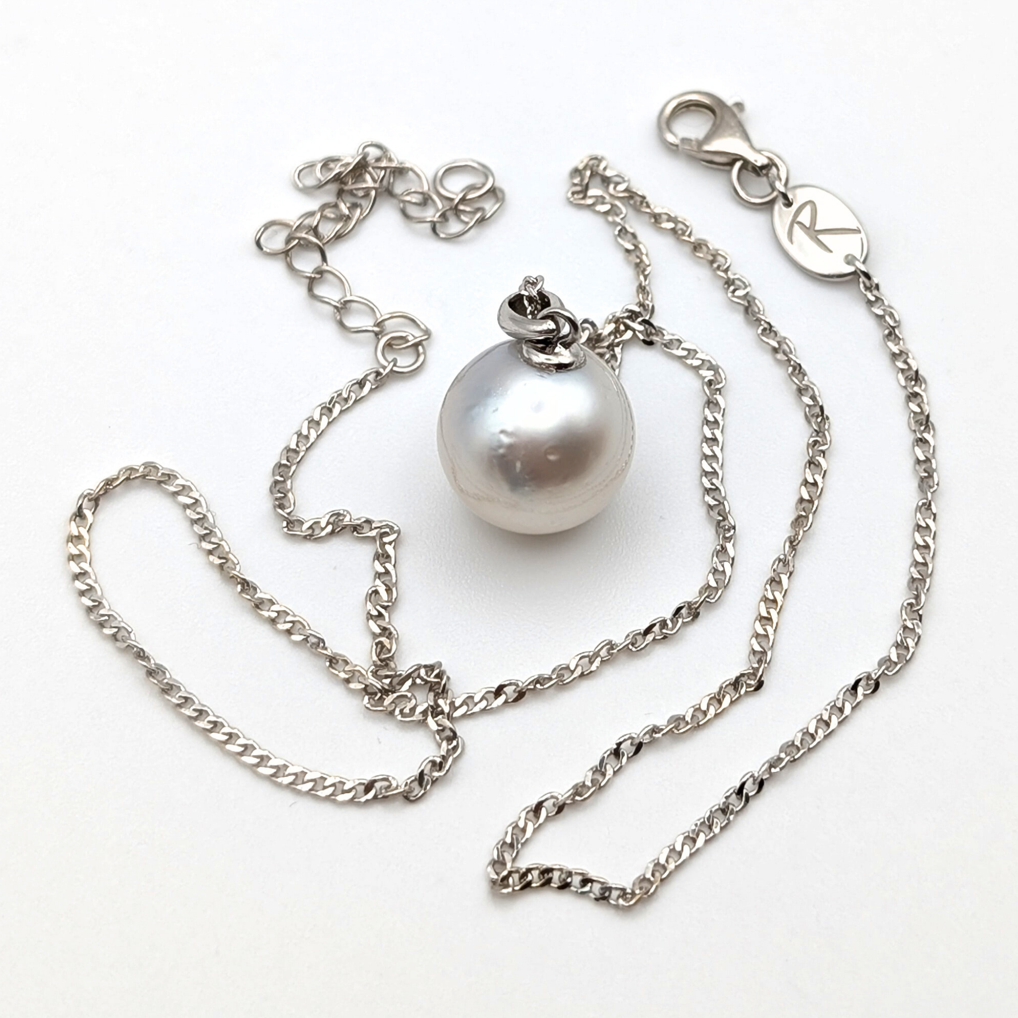 Rhodium plated sterling silver necklace with a large silver south sea pearl pendant on a white background