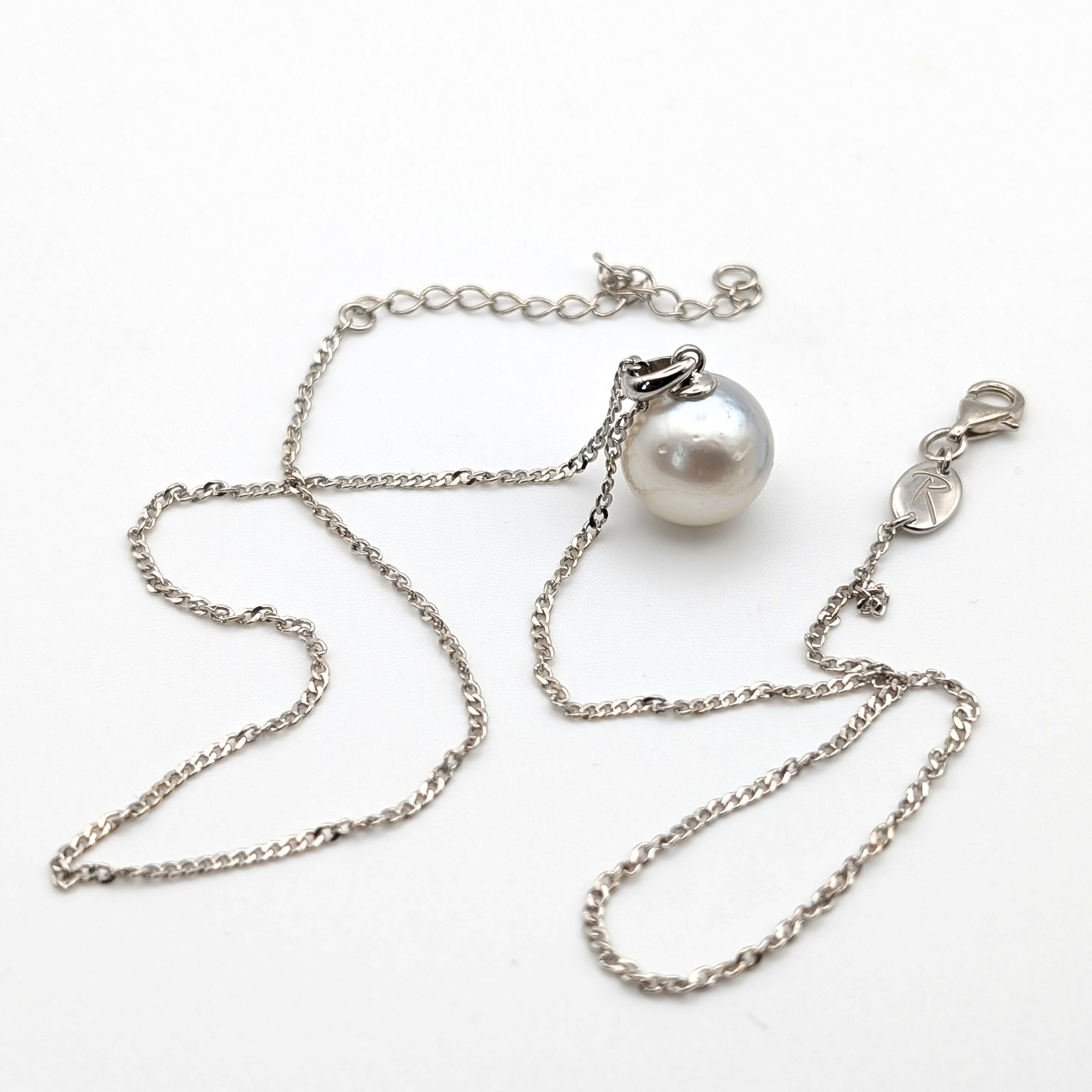 Rhodium plated sterling silver necklace with a large silver south sea pearl pendant on a white background