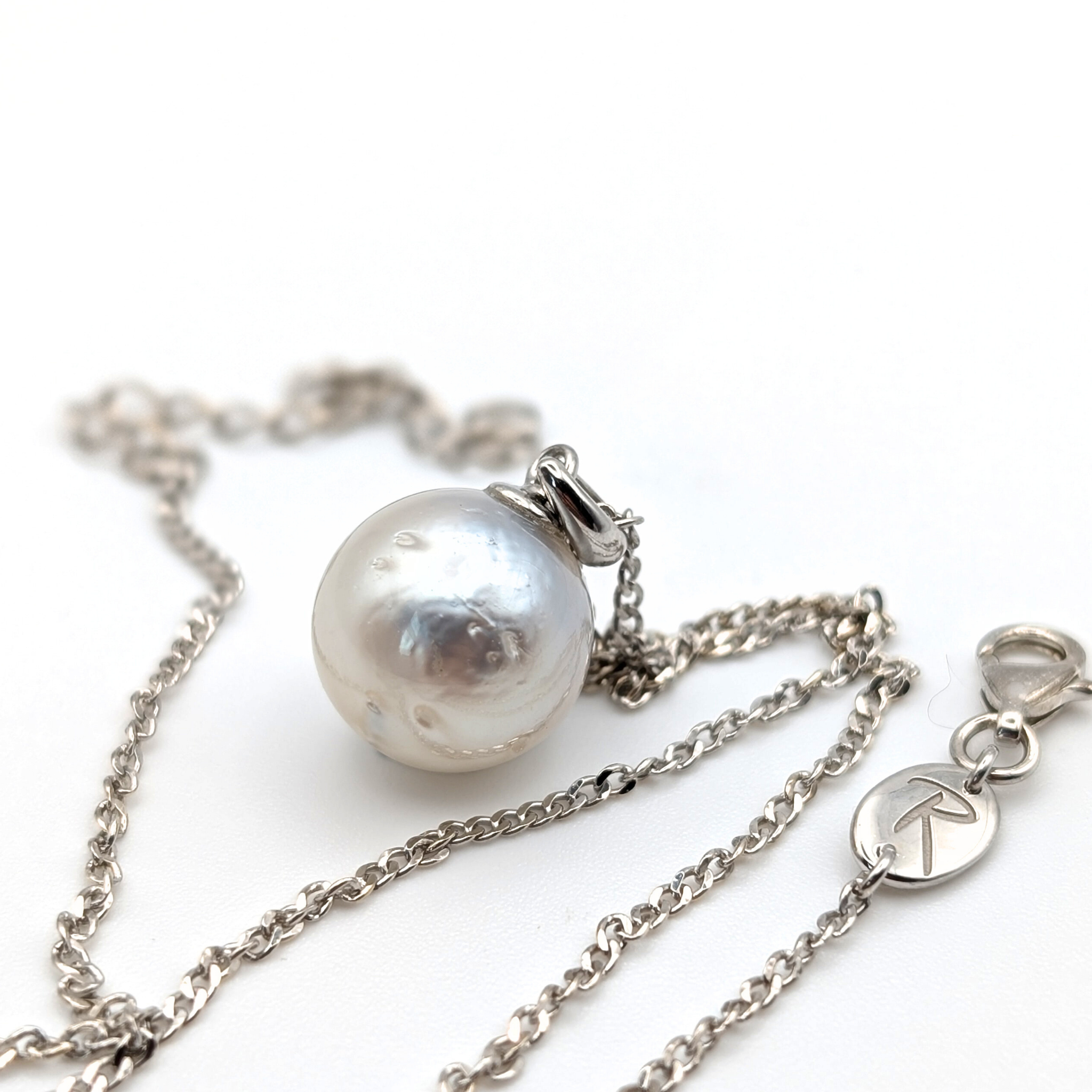 Rhodium plated sterling silver necklace with a large silver south sea pearl pendant on a white background