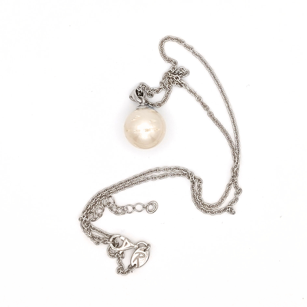 Rhodium plated sterling silver necklace with a large white spotted south sea pearl pendant on a white background