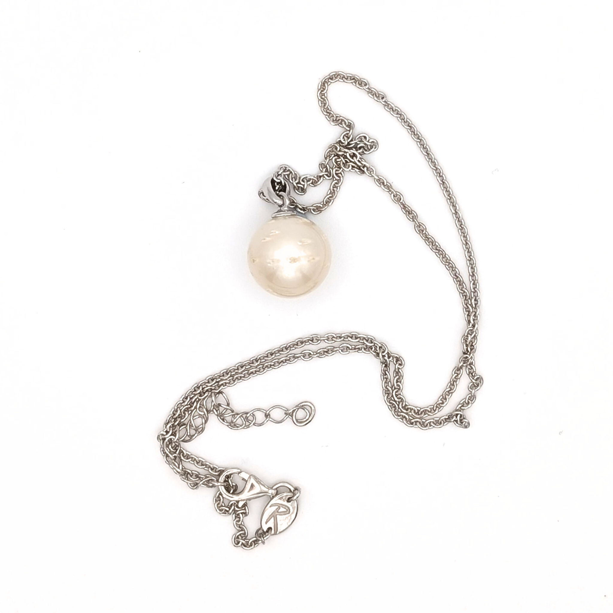 Rhodium plated sterling silver necklace with a large white spotted south sea pearl pendant on a white background