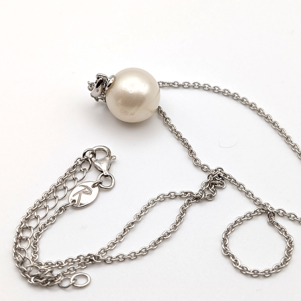 Rhodium plated sterling silver necklace with a large white spotted south sea pearl pendant on a white background