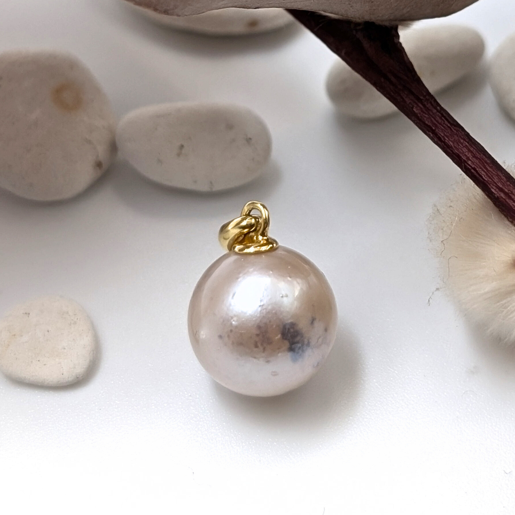 large pink south sea pearl with gold vermeil bail and pebble back ground